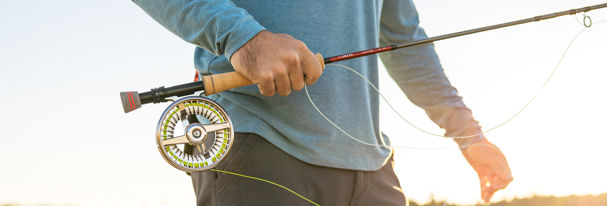 Man holding fly fishing rod and reel